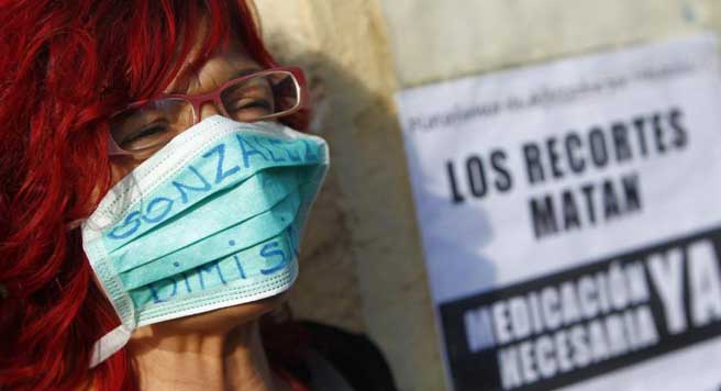 Una manifestante pide dimisiones en la Comunidad de Madrid tras el contagio de una auxiliar de enfermería por ébola. (JORGE PARÍS)